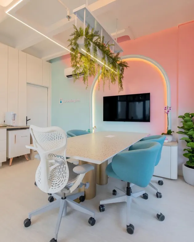 Sala de reuniões do escritório da Branding Lab, com paredes em tons pastel